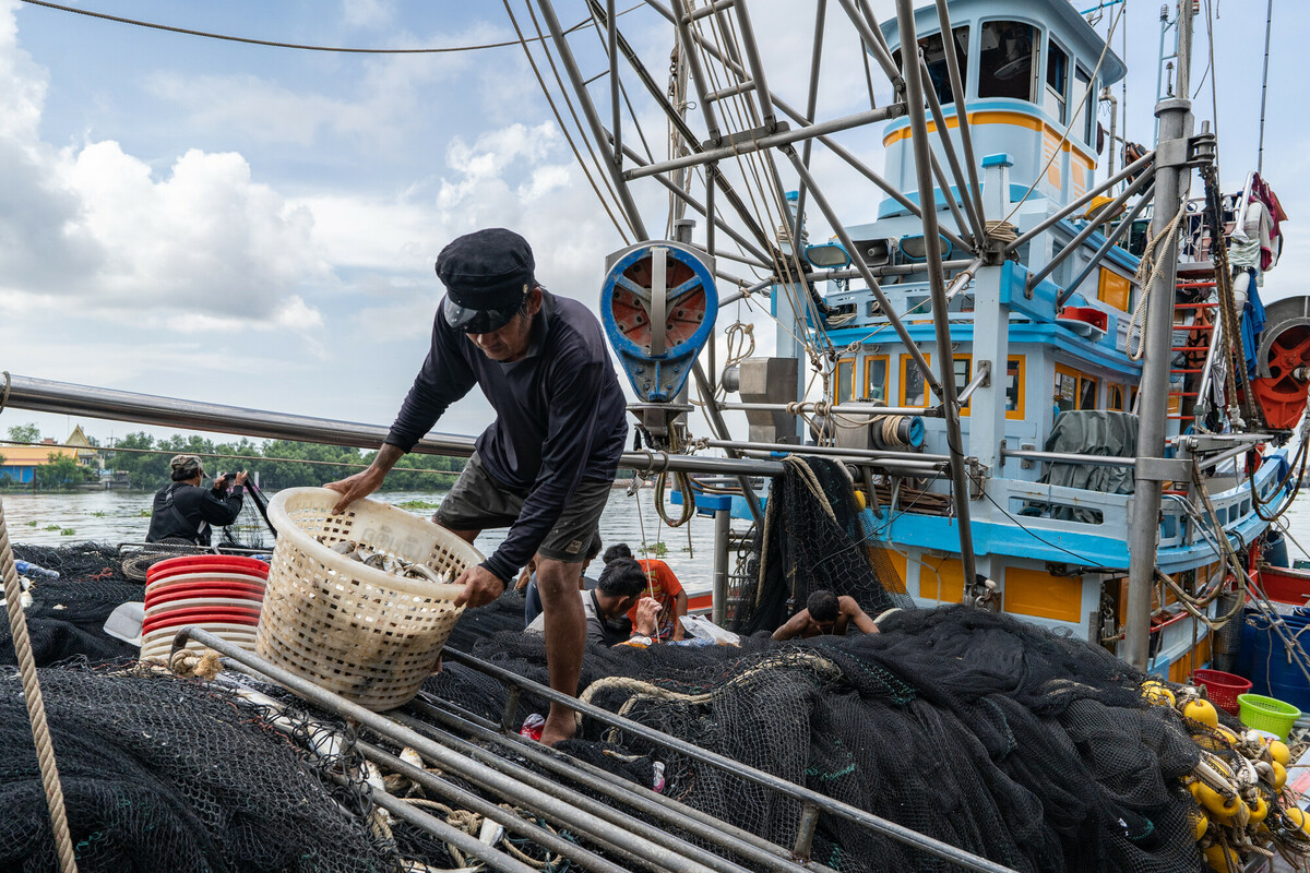 Fishing industry in Samut Sakhon, Thailand. Thailand is a top 5 global seafood producer, with exports reaping over $7 billion. But the profitable industry supplying consumers around the world with cheap seafood comes at a high cost to both the environment and to workers. The overwhelming majority of workers in Thailands fishing and seafood processing industries are migrants from Myanmar, Laos and Cambodia. Labour brokers recruit from vulnerable communities, promising favourable employment in the construction, manufacturing, or agriculture industries. Migrants often incur debt from their recruitment, fees and costs associated with transportation and securing employment in Thailand. These debts are paid off through deductions from workers earnings with employers and brokers frequently using debt manipulation to inflate the amounts and force people into bonded labour. This and the other images in this collection are showing the context in which the Freedom Fund Thailand hotspot operates. They show the location as well as the boats on which migrant workers work. They also show facilities for processing seafood and the markets in which seafood is traded. We do not have names or stories of any of the individuals shown in this collection because that was not the purpose of this commission. Photo: Jittrapon Kaicome / The Freedom Fund