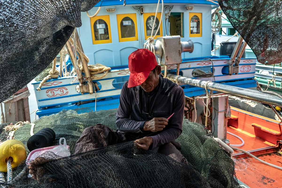 Fishing industry in Samut Sakhon, Thailand. Thailand is a top 5 global seafood producer, with exports reaping over $7 billion. But the profitable industry supplying consumers around the world with cheap seafood comes at a high cost to both the environment and to workers. The overwhelming majority of workers in Thailands fishing and seafood processing industries are migrants from Myanmar, Laos and Cambodia. Labour brokers recruit from vulnerable communities, promising favourable employment in the construction, manufacturing, or agriculture industries. Migrants often incur debt from their recruitment, fees and costs associated with transportation and securing employment in Thailand. These debts are paid off through deductions from workers earnings with employers and brokers frequently using debt manipulation to inflate the amounts and force people into bonded labour. This and the other images in this collection are showing the context in which the Freedom Fund Thailand hotspot operates. They show the location as well as the boats on which migrant workers work. They also show facilities for processing seafood and the markets in which seafood is traded. We do not have names or stories of any of the individuals shown in this collection because that was not the purpose of this commission. Jittrapon Kaicome / The Freedom Fund